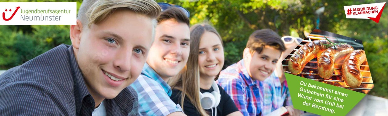 Vier Jugendliche sitzen draußen und lächeln in die Kamera