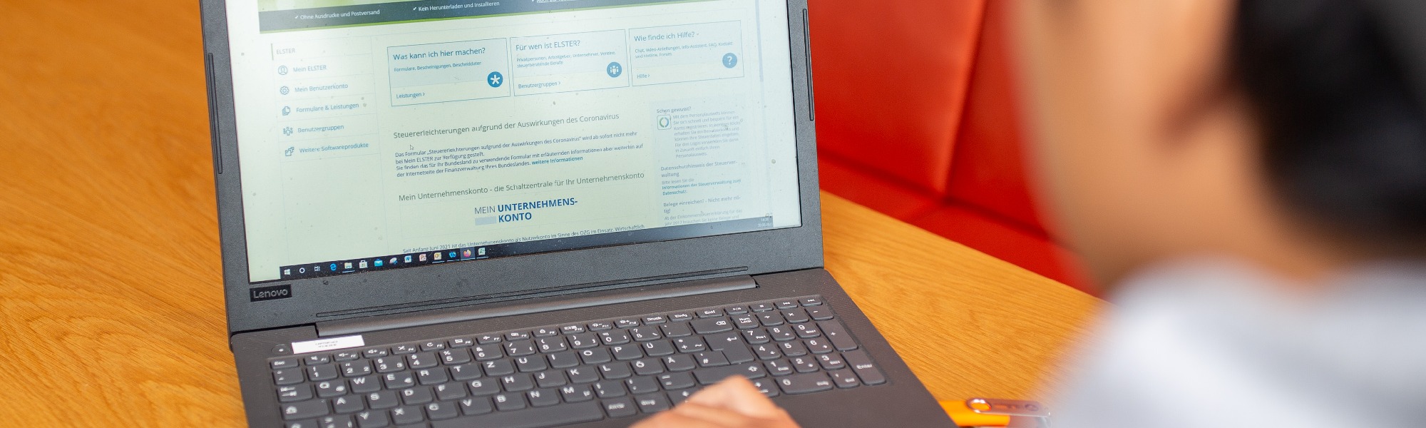 Man is sitting in front of the computer, german tax website is open on the screen