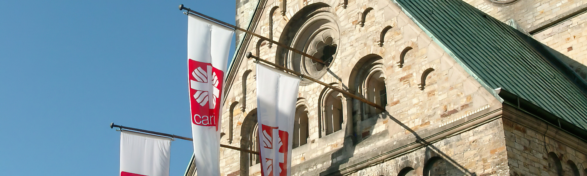 Caritas Fahnen hängen am Paderborner Dom.